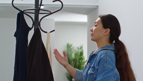 mujer volviendo a casa de las compras de comida colgando el abrigo y llevando una bolsa de verduras frescas adentro en la cocina 1