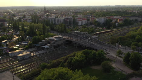 Vuela-Junto-Con-La-Línea-Ferroviaria-De-Múltiples-Vías.-Vista-Aérea-De-La-Infraestructura-De-Transporte-Que-Atraviesa-La-Ciudad-Al-Sol-De-La-Tarde.-Berlín,-Alemania