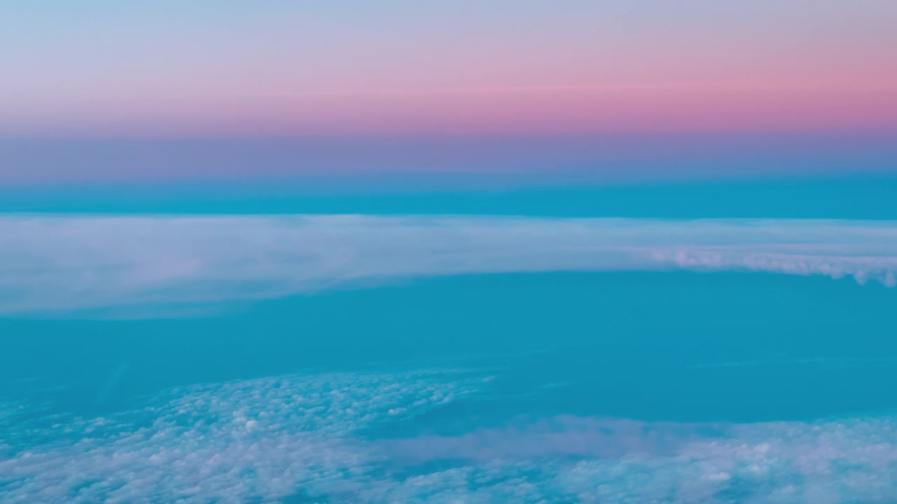 Gradientes de céu rosa e azul acima de nuvens esparsas formando um pano de fundo aéreo abstrato