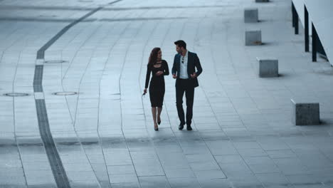 young business couple talking in stylish clothing outside