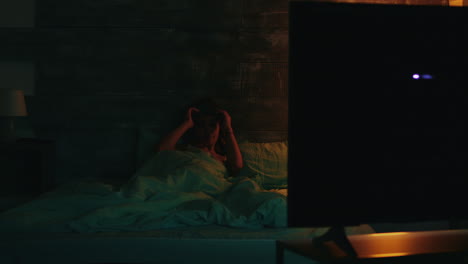 mujer somnolienta en pijama aplaudiendo para apagar las luces