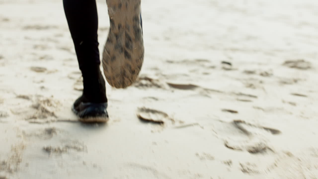 Corsa, fitness e piedi di persona sulla spiaggia