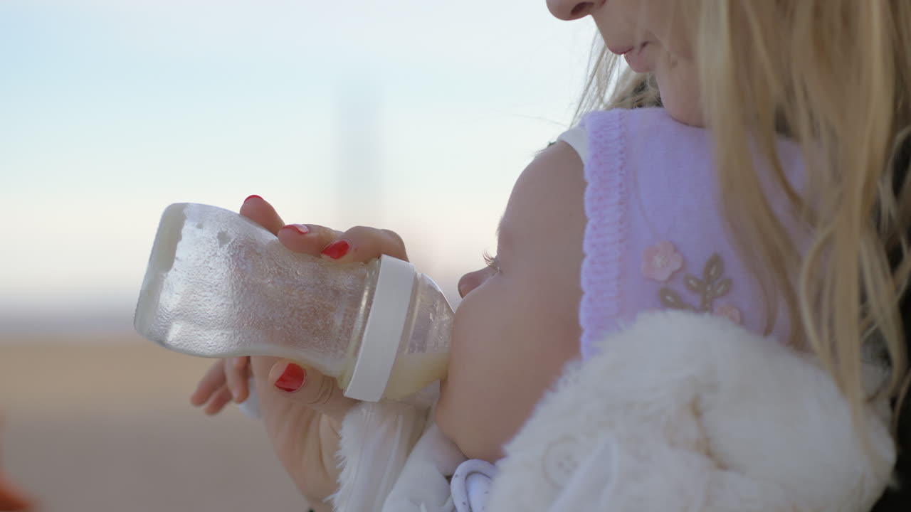 Madre alimentando a su bebé al aire libre
