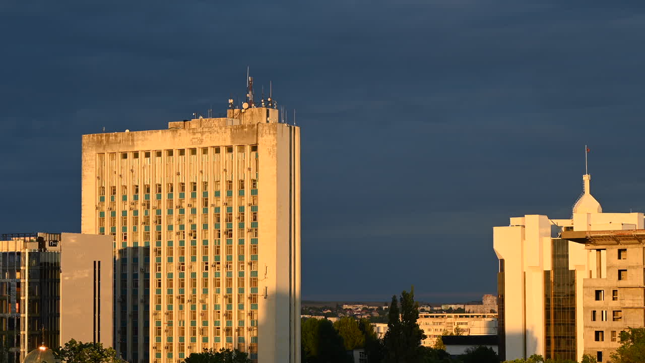 Time lapse of tall office buildings illuminated by warm sunset light