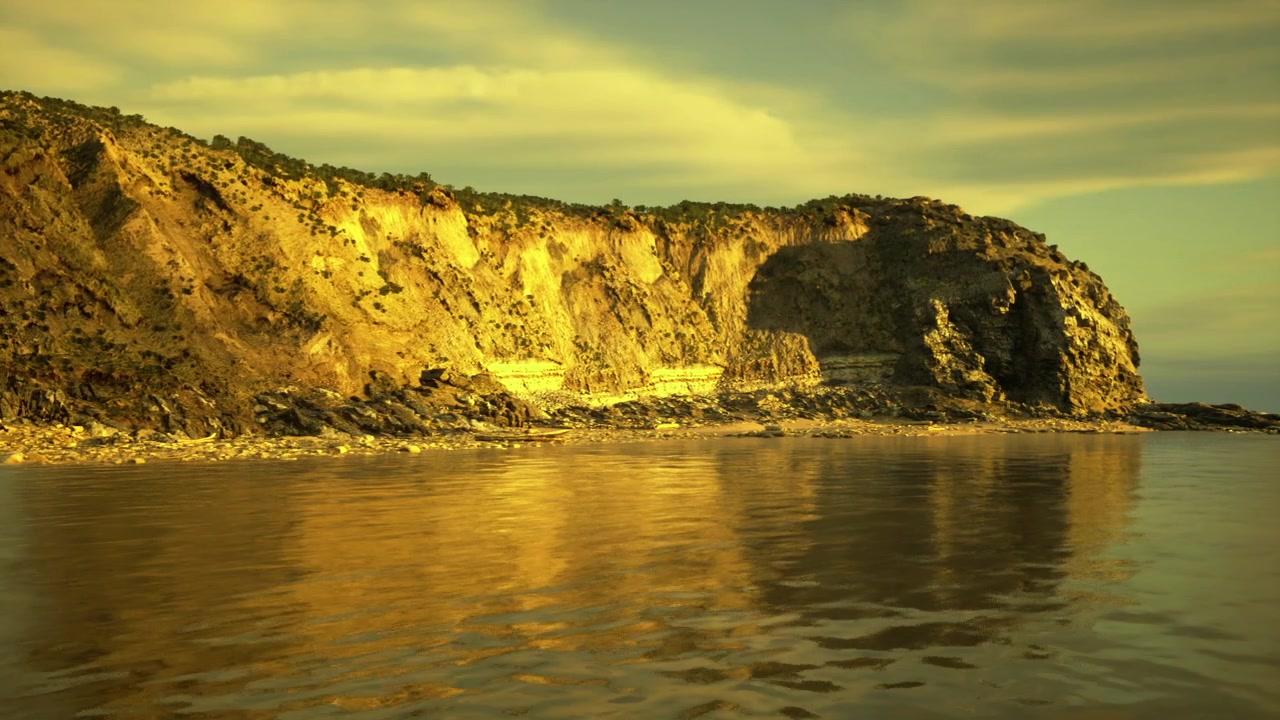 Paesaggio serale drammatico con nuvole colorate e rocce texturizzate che creano atmosfera.
