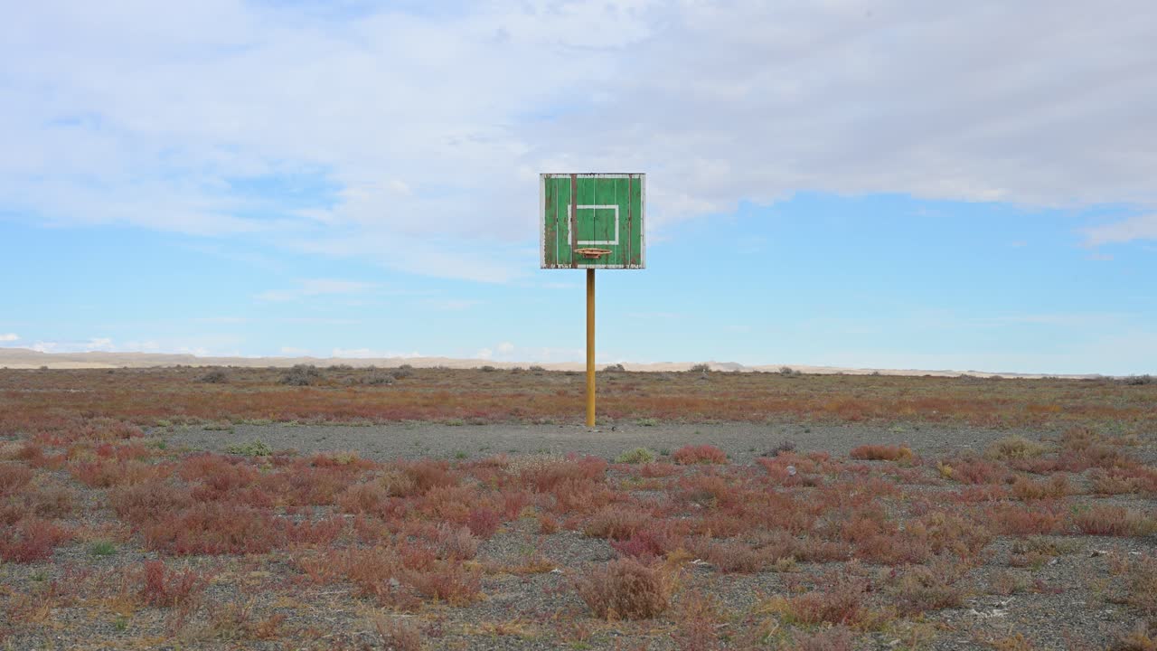 A forgotten basketball court in remote Mongolia, where a single, dilapidated hoop is all that remains. A poignant symbol of past games, community, and abandoned childhood dreams