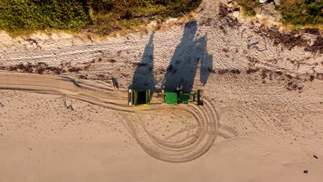 Aerial-drone-bird's-eye-shot-of-tractor-cleaning-beach-sand-dunes-Pacific-ocean-rural-town-main-Port-Macquarie-NSW-Mid-north-coast-transport-Australia-4K