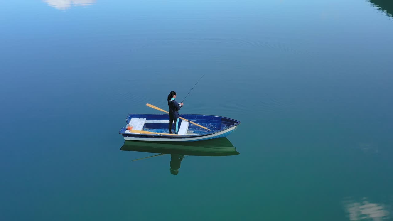 la mujer en el barco atrapa un pez en el giro en noruega.