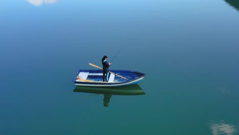 la mujer en el barco atrapa un pez en el giro en noruega.