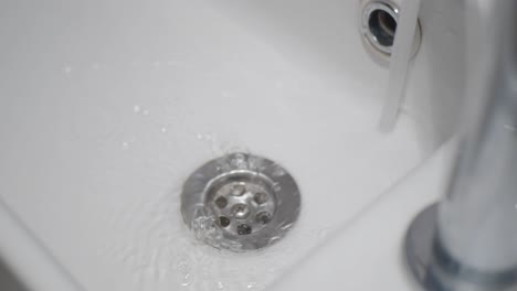 close-up of a white sink with water draining