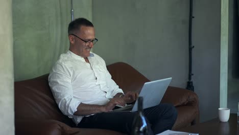 Smiling-businessman-working-on-laptop-computer-at-home-office.-Male-professional-typing-on-laptop-keyboard-at-office-workplace