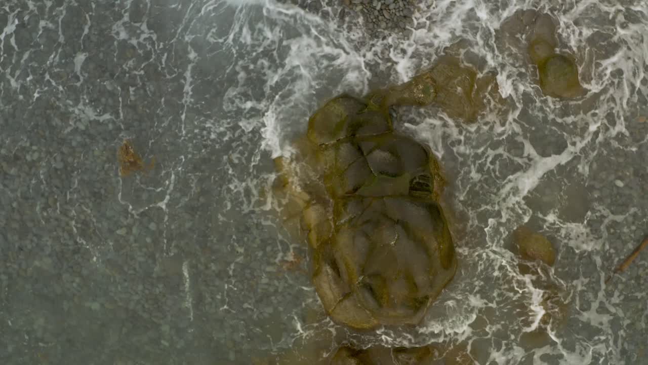 vista desde arriba sobre una roca de rocas en una playa con olas del océano en la bahía de looc, filipinas