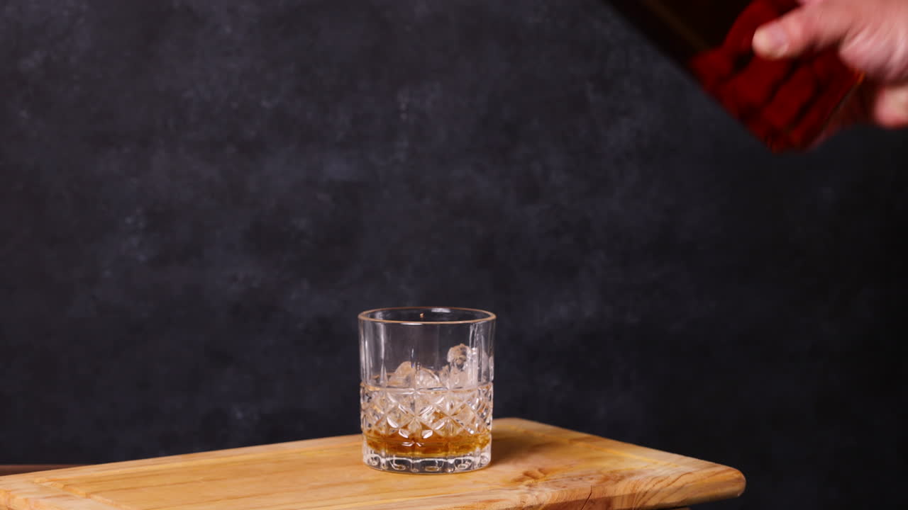 whisky con hielo, fondo oscuro mesa de madera