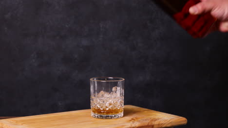 Whisky-Con-Hielo,-Mesa-De-Madera-De-Fondo-Oscuro