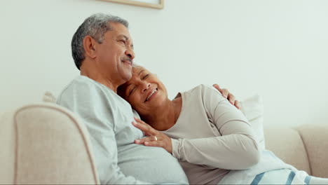 senior couple hug, kiss or relax on sofa with home