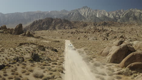 drone footage of iconic off-road track, with rv driving towards sierra nevada mountains in alabama hills on american road trip