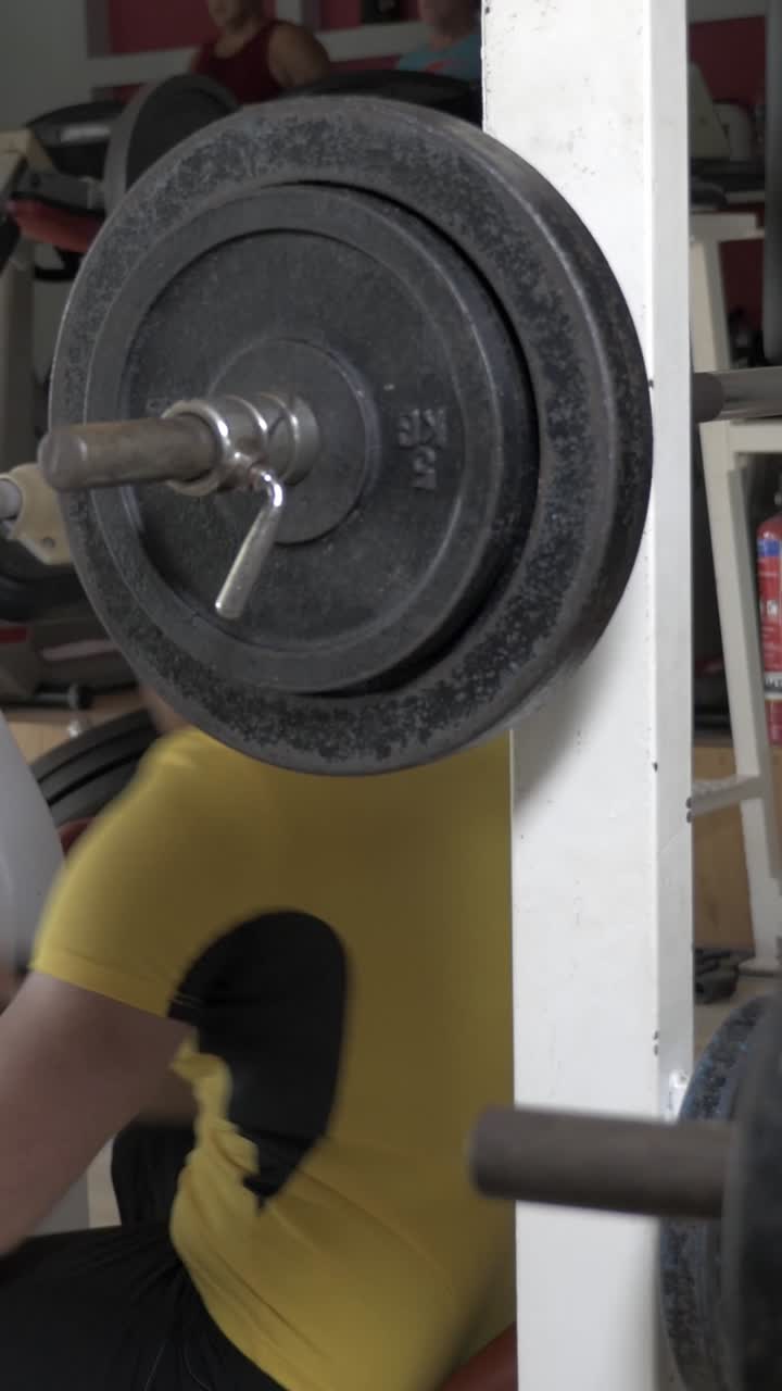 Man Performing Bench Press Exercise in a Gym