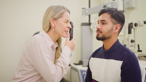 hombre en el optometrista haciendo un examen de la vista para comprobar