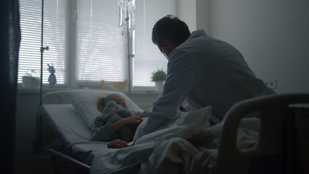Doctor examining child stethoscope in hospital ward. Sick kid on daily checkup.