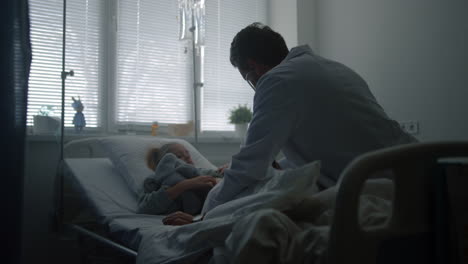 Doctor-examining-child-stethoscope-in-hospital-ward.-Sick-kid-on-daily-checkup.