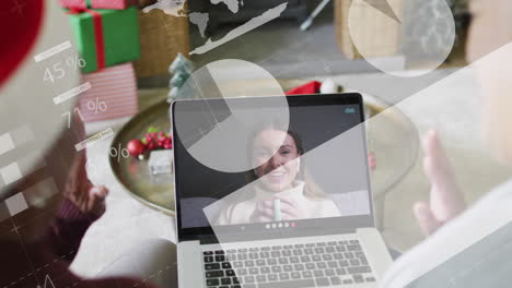 animation of data processing over african american woman on tablet video call at christmas