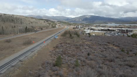 Aerial-view-following-along-Interstate-70-with-cloudy-skies-and-fresh-snow