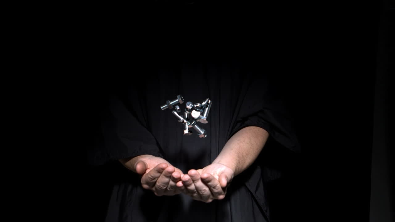 스크루와 볼트를 던지는 사람의 손