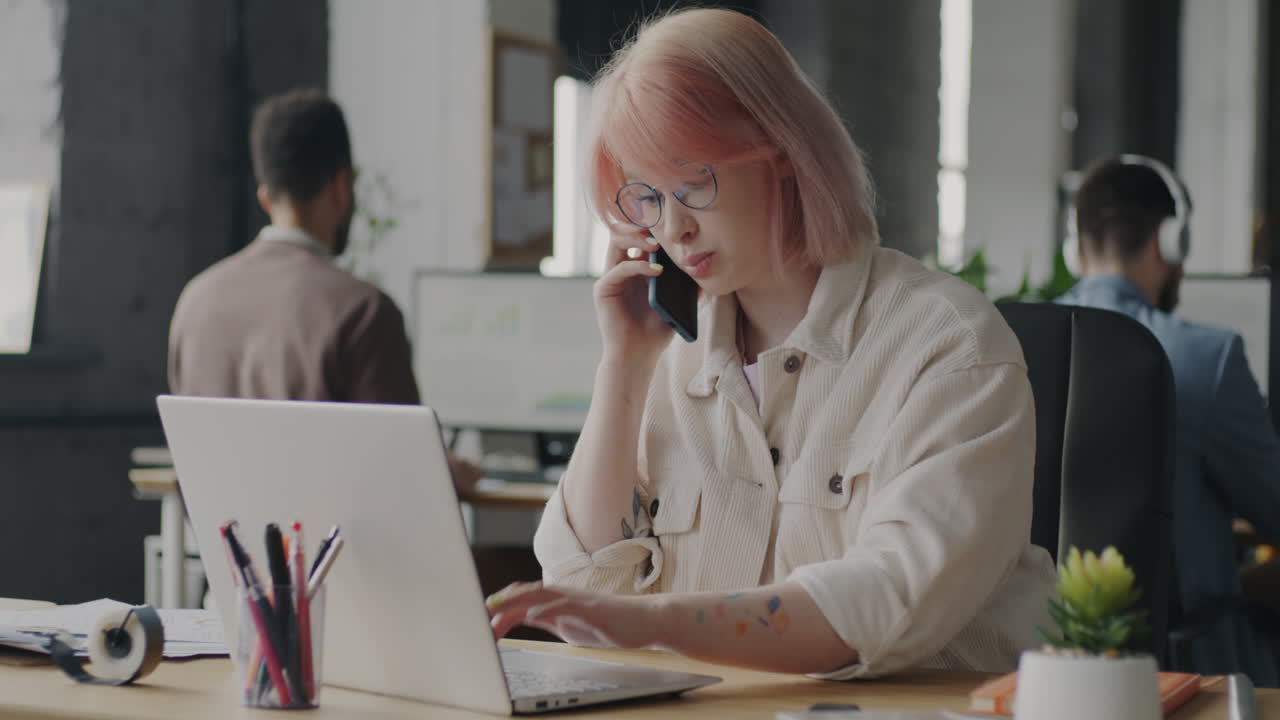 Kvinde taler i telefon på kontor