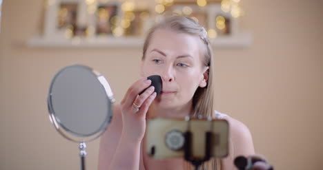 atractiva mujer haciendo maquillaje aplicando polvo 3
