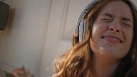 happy girl singing headphones at home closeup. energetic pretty female dancing