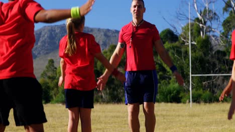 Entrenador-Entrenando-A-Niños-En-El-Campo-De-Entrenamiento.