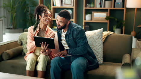 couple relaxing on couch with tablet