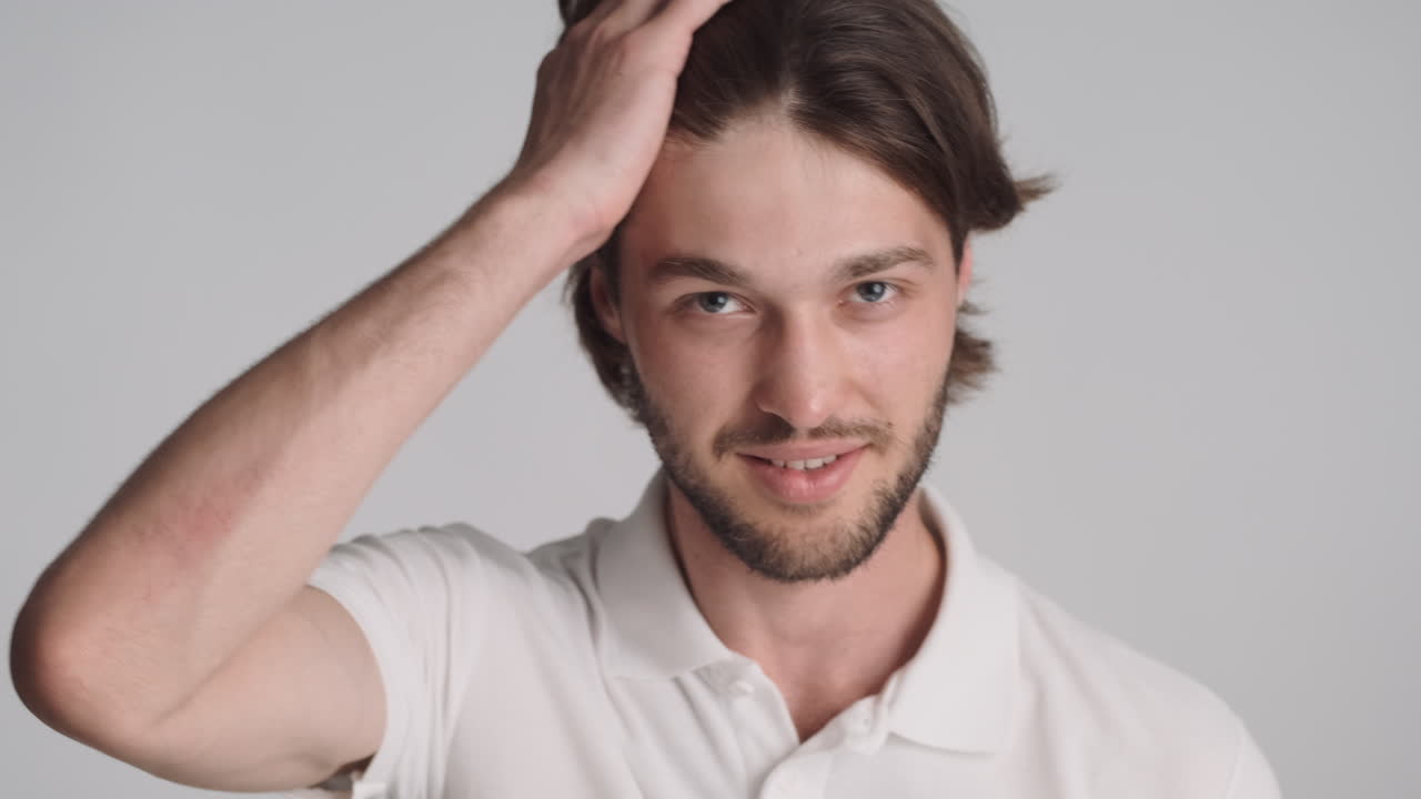 회색 배경에서 카메라 앞에 있는 백인 남자.