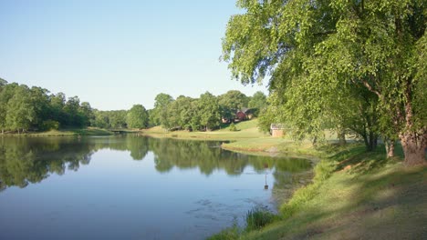 A-golf-course-in-North-Carolina-on-a-warm-spring-morning-overlooking-a-pond-with-birds-flying-in