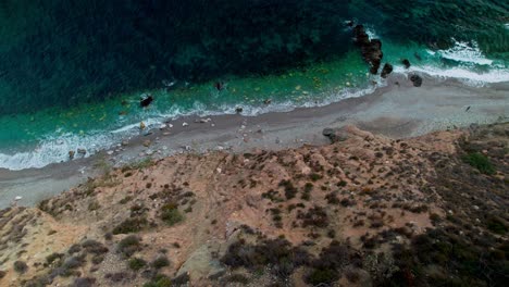 Alta-Vista-Aérea-De-La-Costa-Rocosa-En-Nerja,-Moviéndose-Hacia-Atrás-E-Inclinándose-Hacia-Arriba