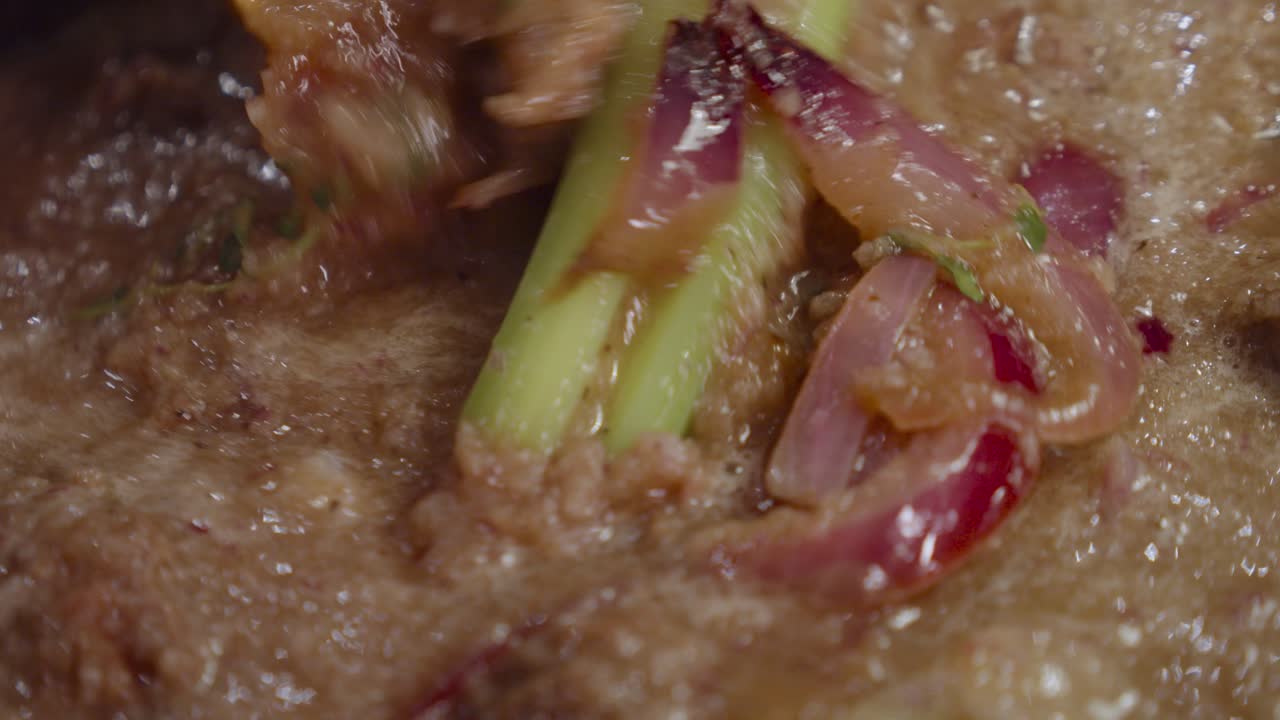 mezclar salsa alla genovese con pierna de res, rodajas de cebolla, apio y especias dentro de una olla profunda