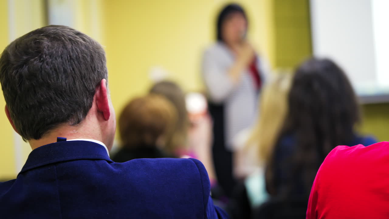 Audience at the conference hall. Speaker giving a talk in conference hall at business event