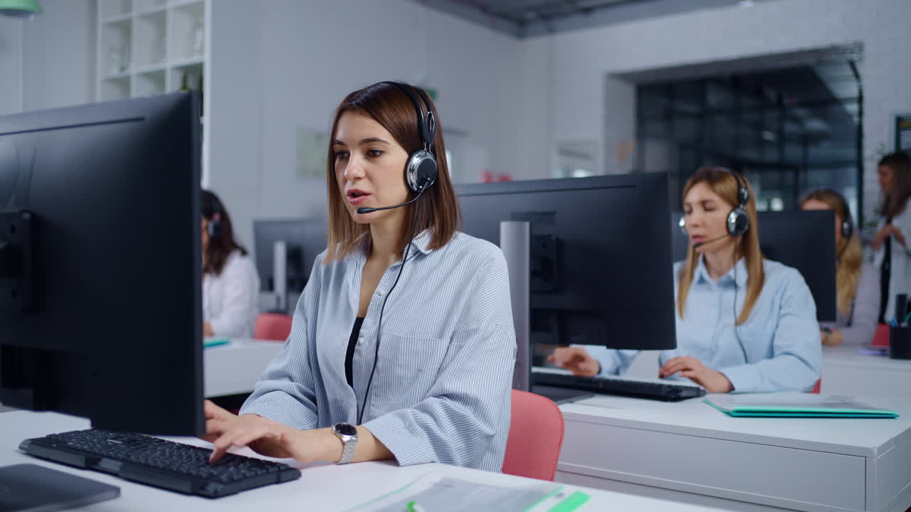 전화 센터 직원들이 컴퓨터에서 일하고 있습니다.