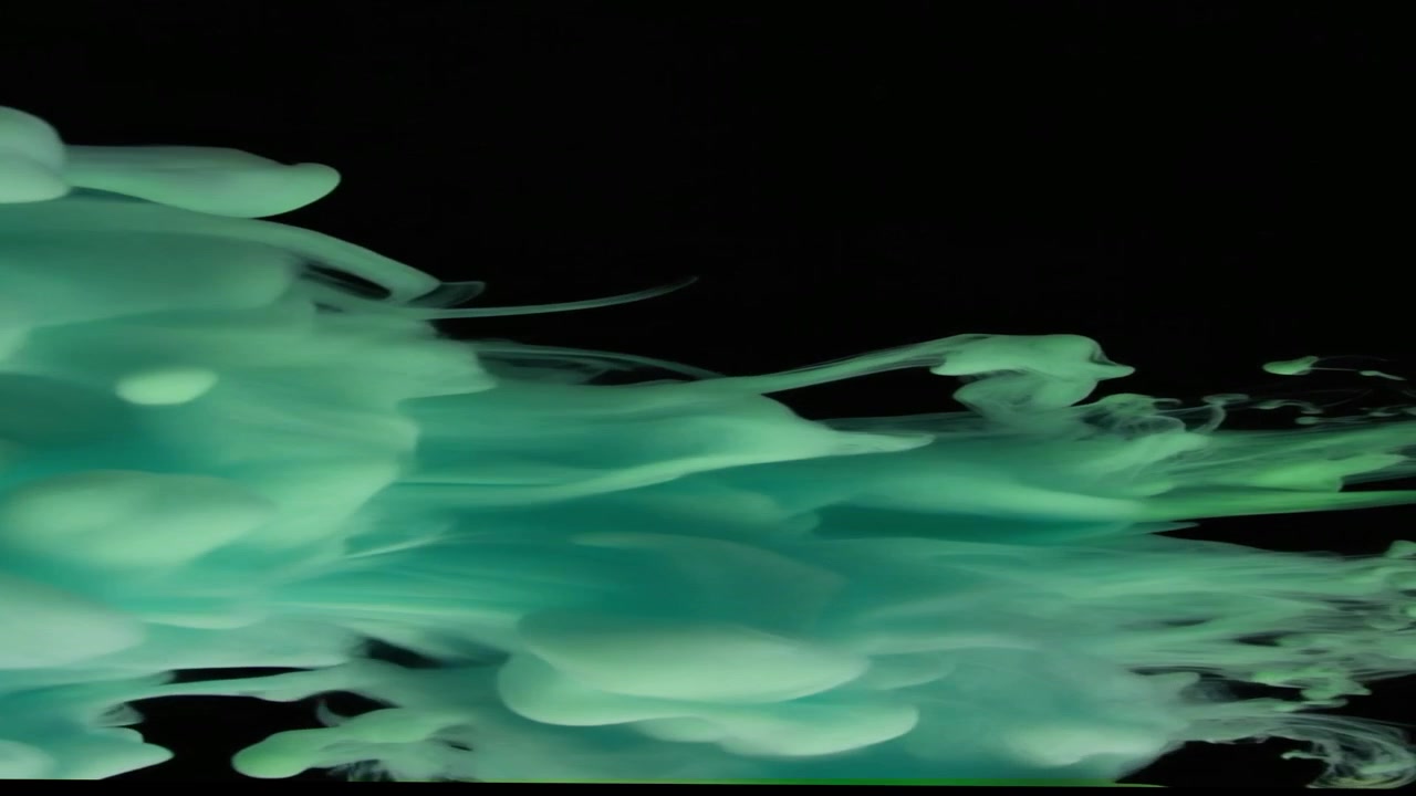 Inchiostro verde che turbina nell'acqua su sfondo nero