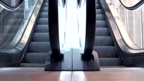 joven caminando por las escaleras mecánicas modernas. escalera móvil subiendo y bajando. concepto de estilo de vida urbano.