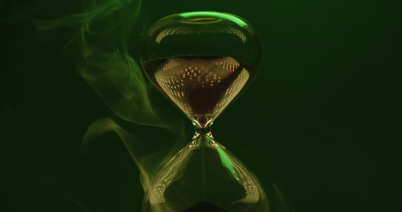 Sand clock on emerald background