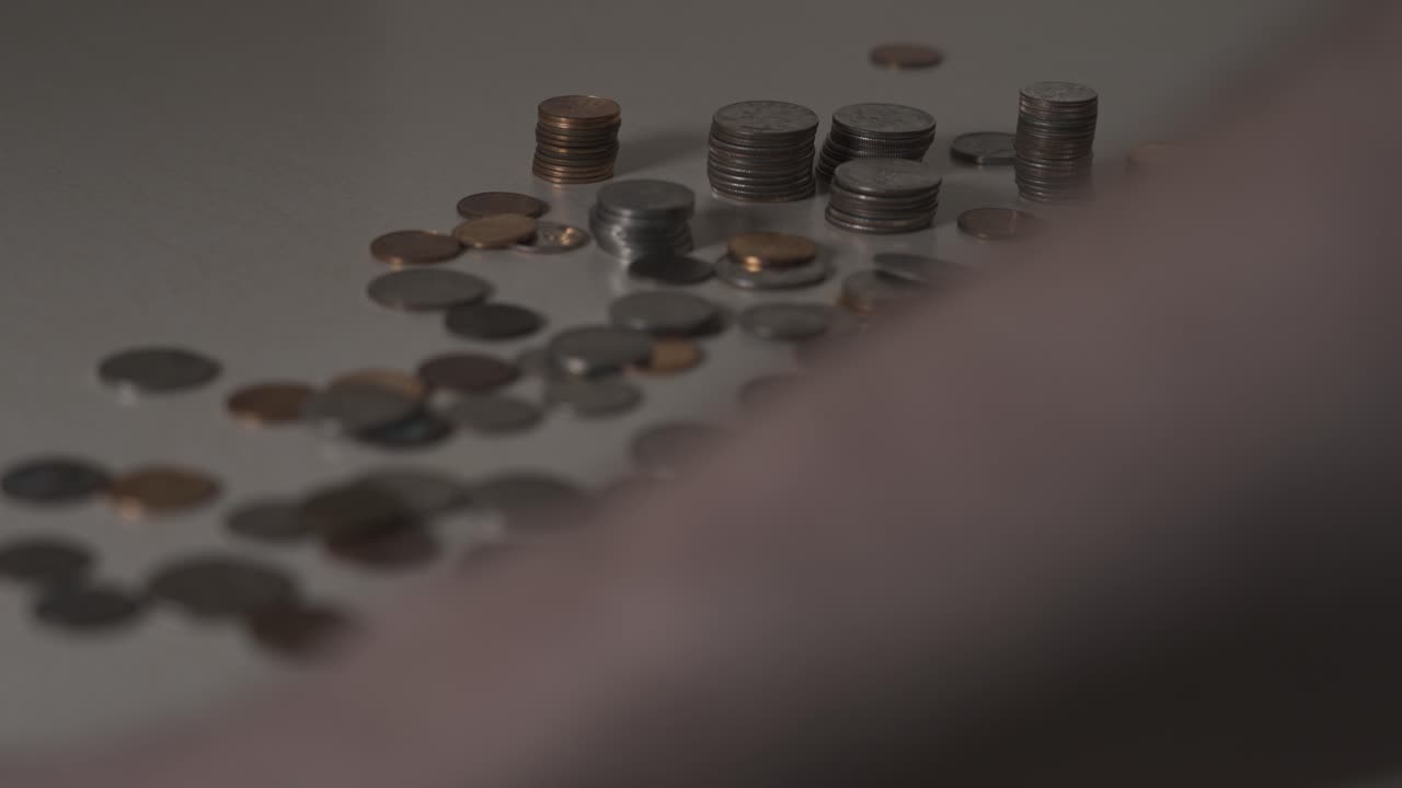 clip de cámara lenta de alguien limpiando monedas de una pila