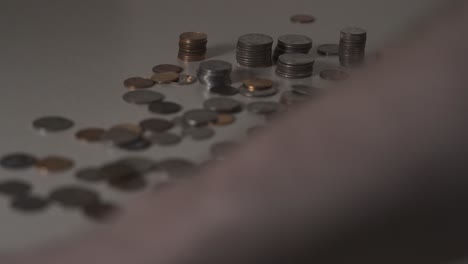 slow motion clip of someone cleaning up coins from a pile