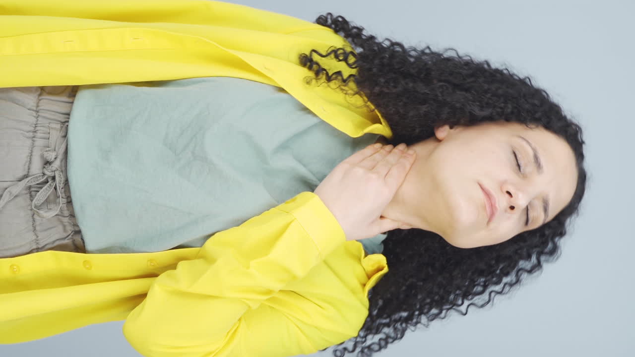 Vertical video of Young woman with sore throat.