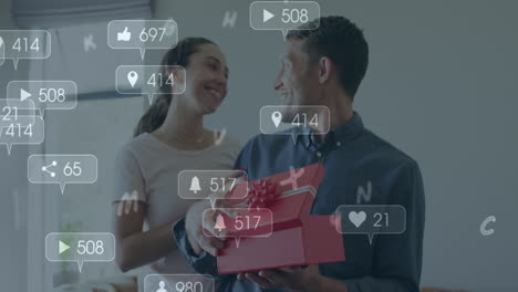 animación de iconos de las redes sociales sobre un hombre caucásico abriendo una caja regalada por su casa en casa.