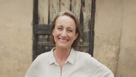 portrait of smiling senior caucasian woman with hands on waist