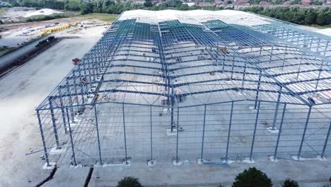 construction industry metal iron girder warehouse framework construction site aerial view rise up tilt follow