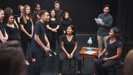 teacher with drama students at performing arts school in studio improvisation class