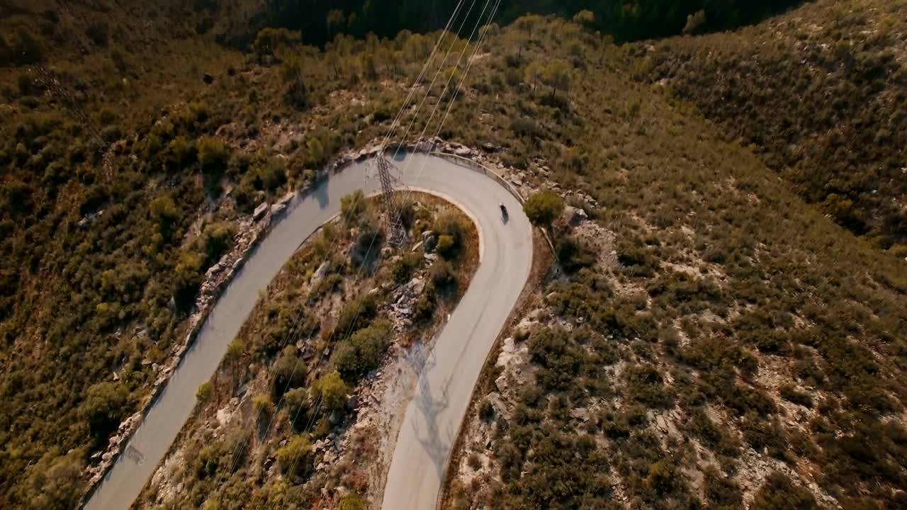imágenes de drones sobre viajero solitario montando su motocicleta en épicos caminos de montaña
