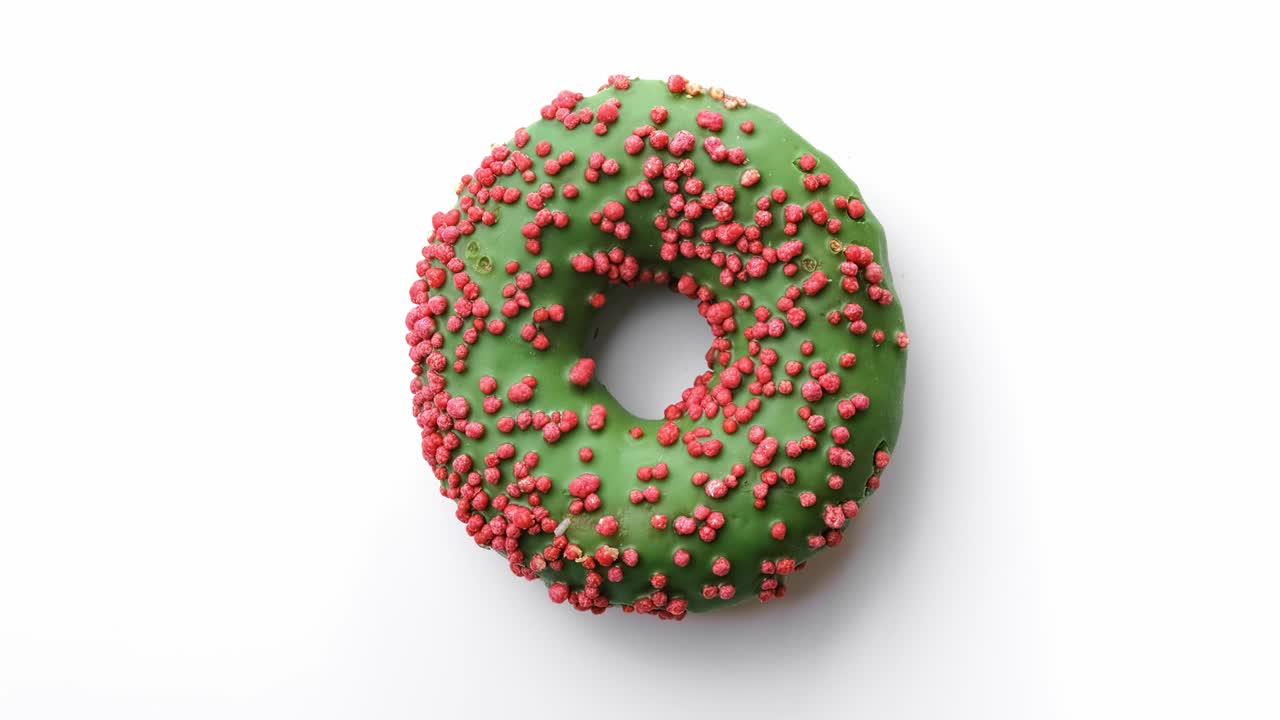 primer plano dulce deliciosa rosquilla con esmaltado verde y topping de pastel rosa. filmado con cámara roja en 4k